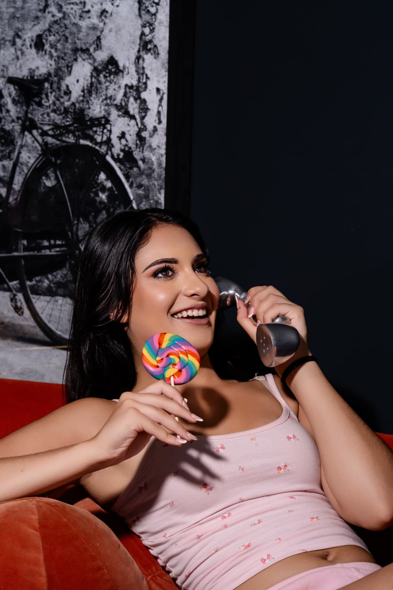 Smiling client on a retro phone with a lollipop